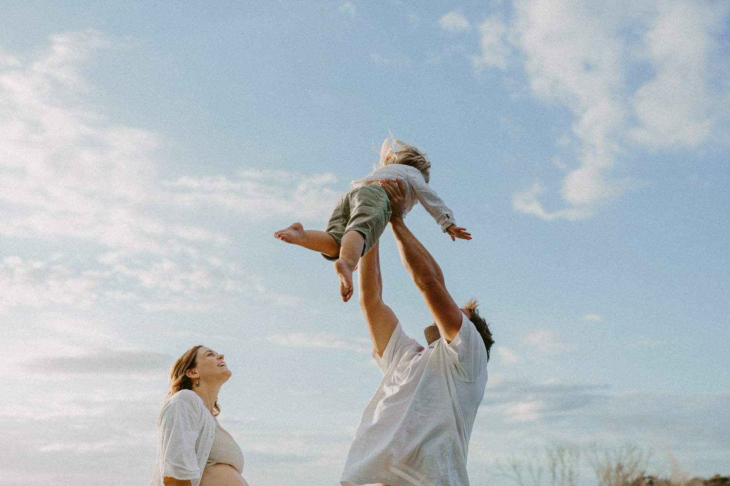 dad throwing kid in air at beach