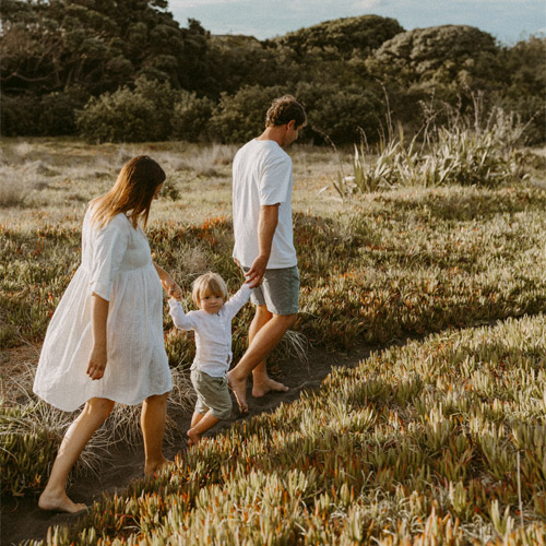 stylish young family walking at beach