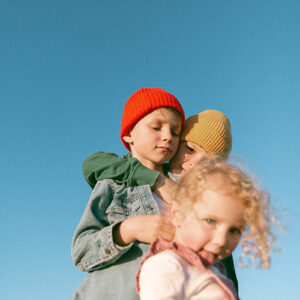 kids in bright beanies against blue sky