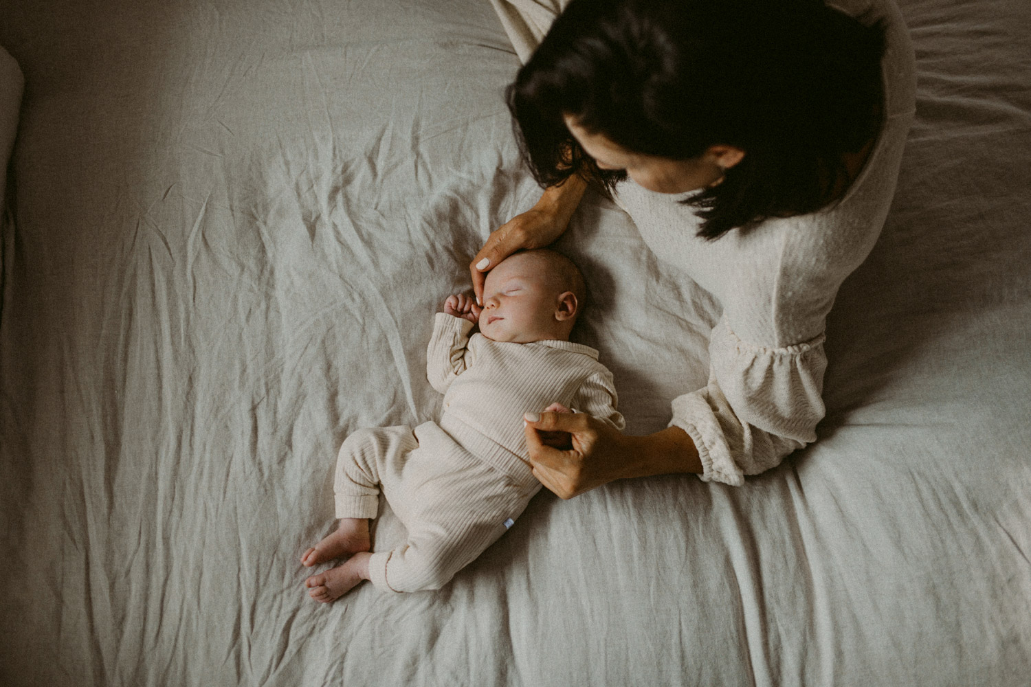 Natural colours with Mum and newborn baby on linen bed