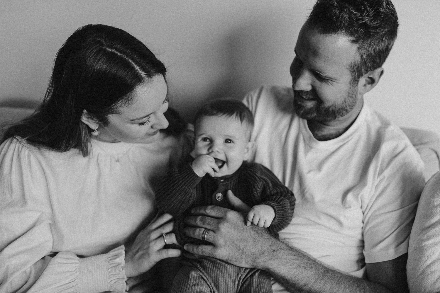 Happy joyful family photo of parents with baby