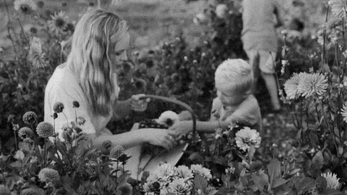 Mum picking flowers in her garden with her children