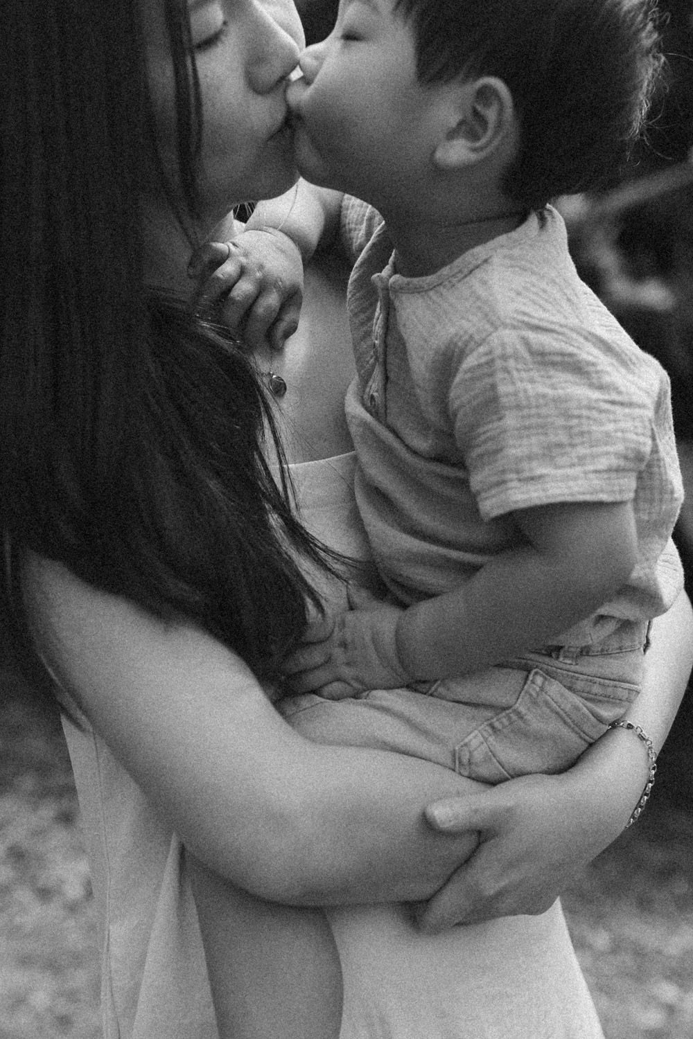 Mother holding son and giving him a kiss