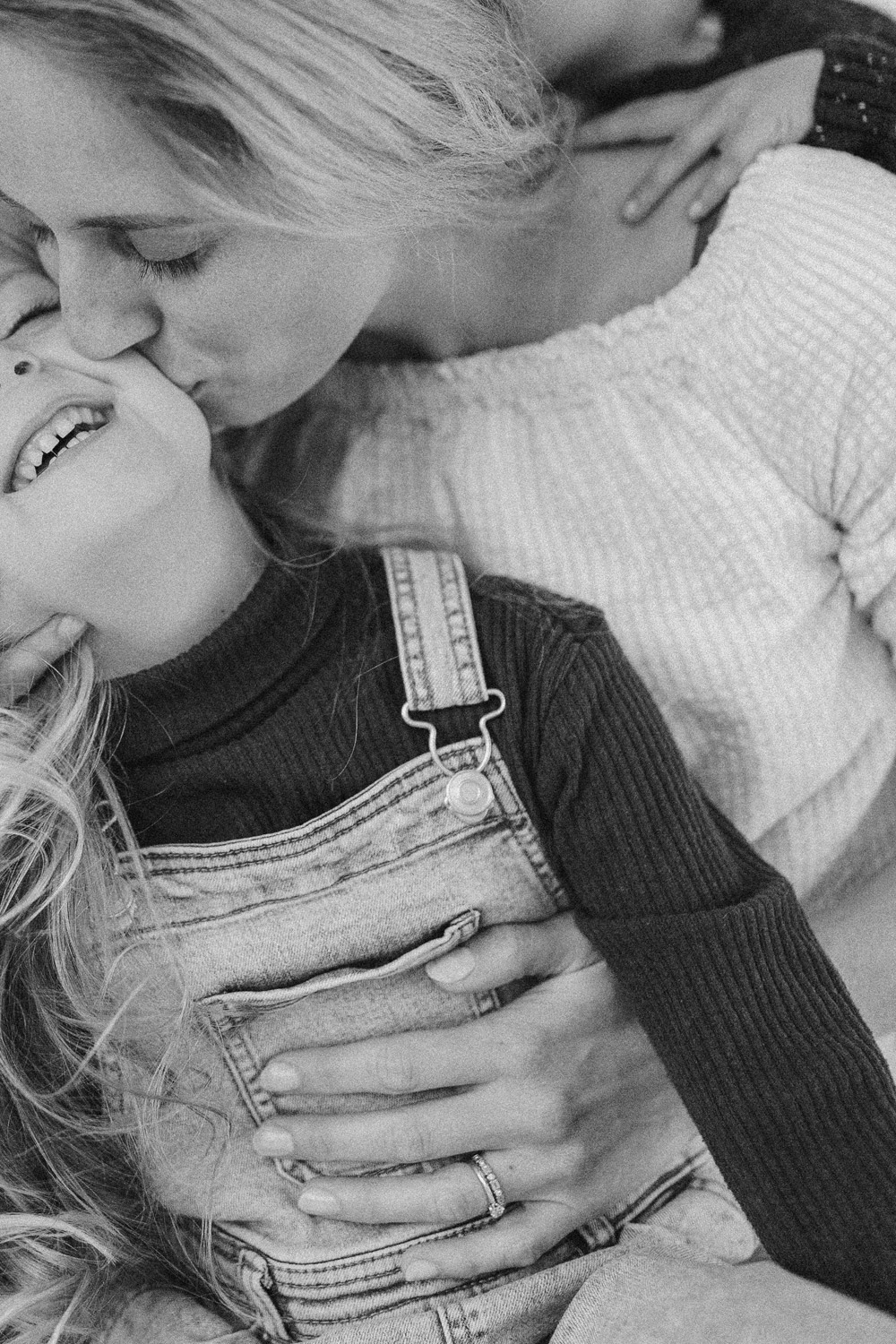 Portrait of a mum kissing her little girl