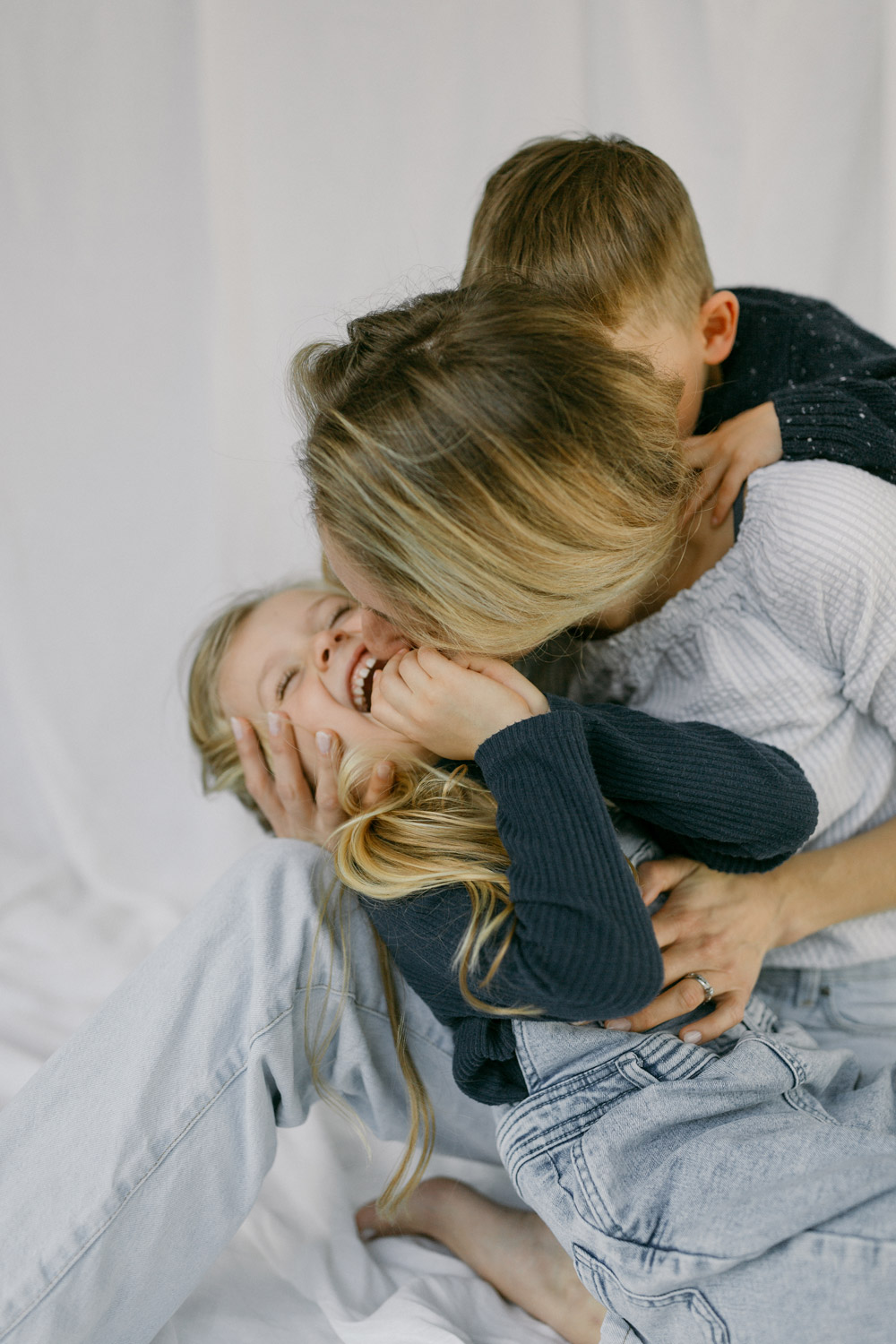 Portrait of a mum kissing her little girl, laughing