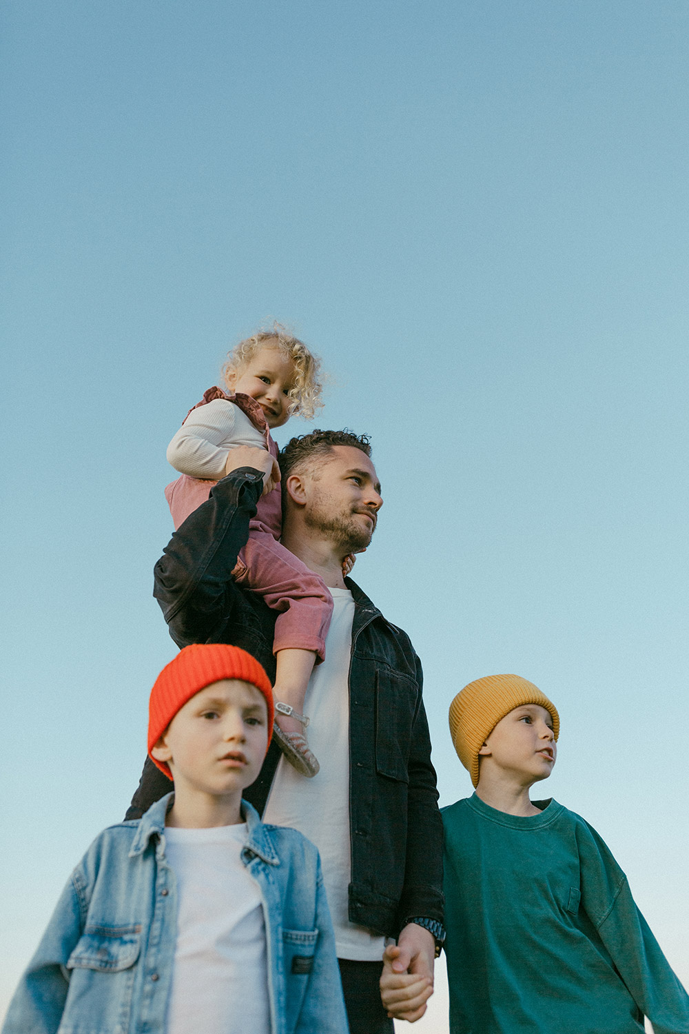 Portrait of Dad with his young kids against the blue sky