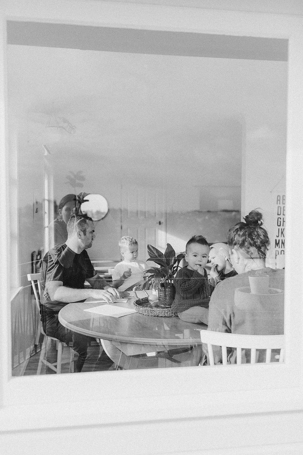 Looking through the window at a young family around their table