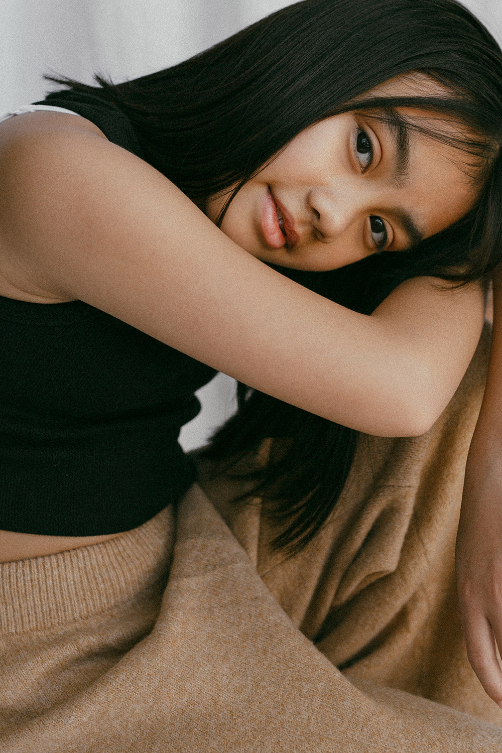Young girl posing for a portrait in front of a white linen backdrop