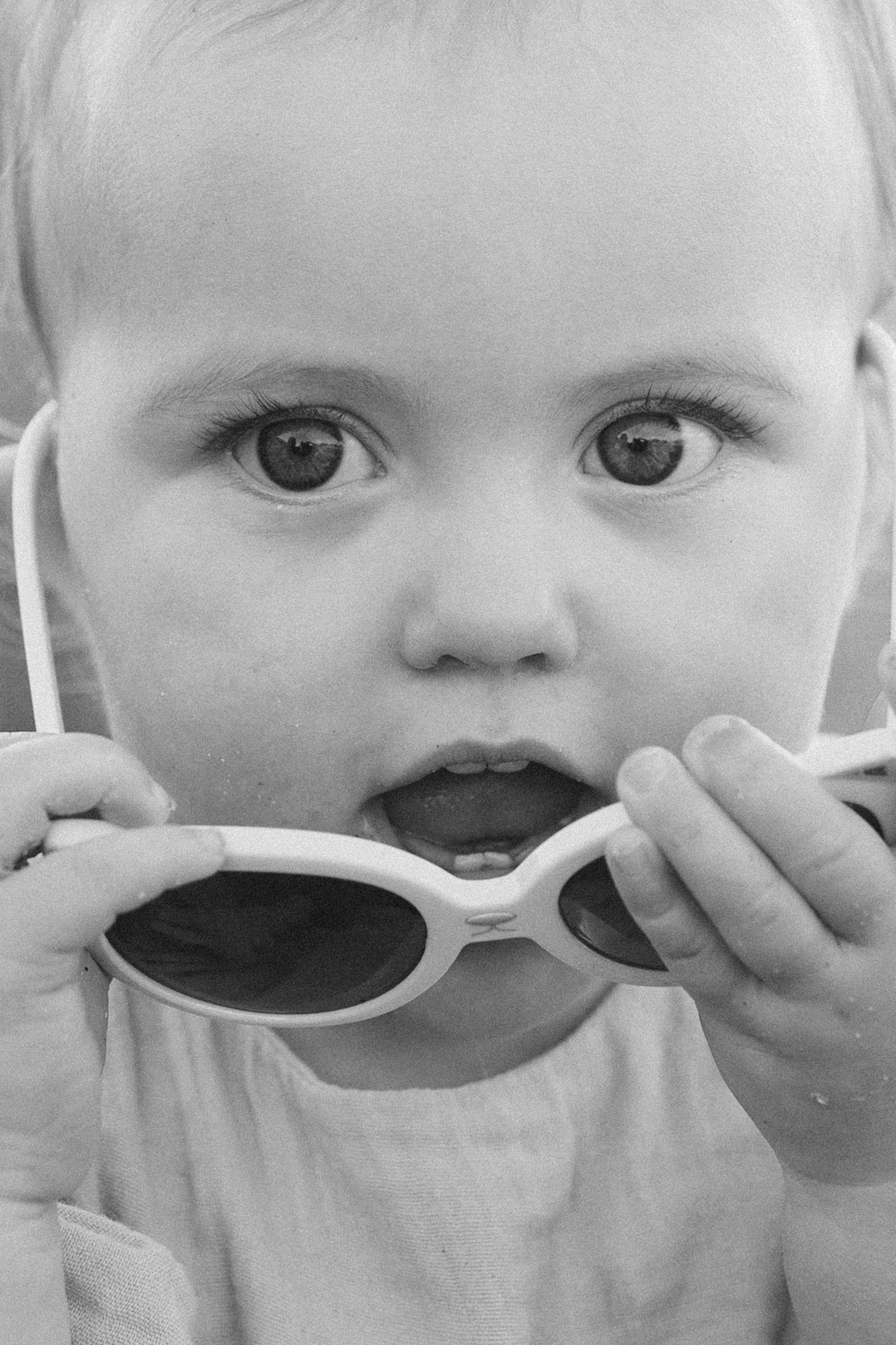 Little girl holding sunglasses